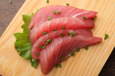 Lezzetli sashimi (yeşil soğanlı taze çiğ ton balığı parçaları) tahtada, görünümün üzerinde