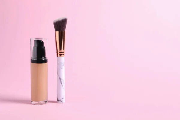 stock image Bottle of skin foundation and brush on pink background, space for text. Makeup product