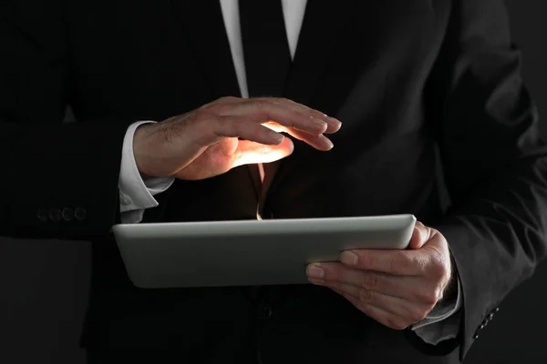stock image Closeup view of businessman using new tablet on black background