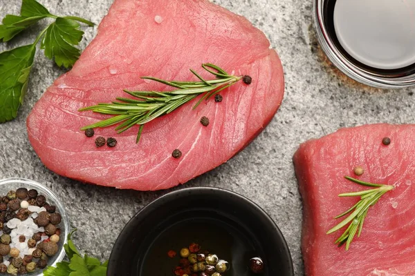 stock image Raw tuna fillets with herbs and spices on gray table, flat lay