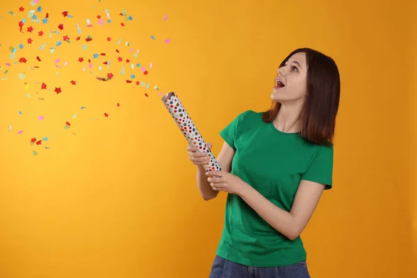 Happy Teenage Girl Blowing Party Popper Orange Background — Stock Photo, Image