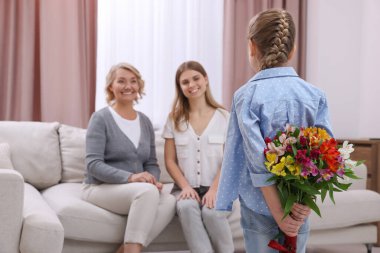 Küçük kız annesini ve büyükannesini evde tebrik ediyor. Anneler Günün kutlu olsun.