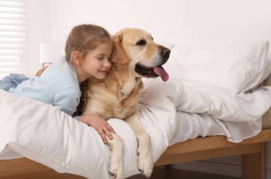 Evde yatakta sevimli köpeğiyle genç bir kız. Metin için boşluk