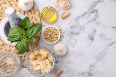 Beyaz mermer masa üzerinde lezzetli pesto sosu pişirmek için farklı malzemeler. Metin için boşluk