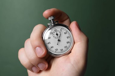 Yeşil arka planda vintage zamanlayıcı tutan adam, yakın plan