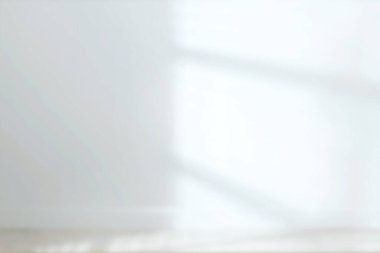 Beyaz duvarlı, tahta zeminli, bulanık manzaralı boş bir oda.