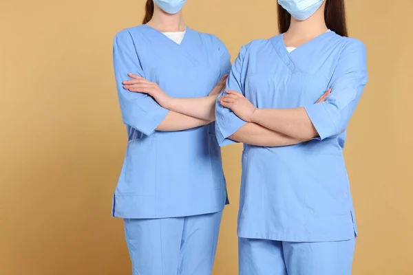 Açık Kahverengi Arka Planda Tıbbi Üniforma Giyen Hemşireler Yakın Plan — Stok fotoğraf