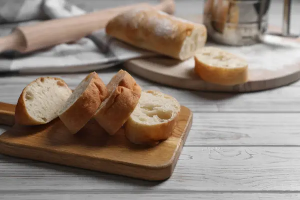 stock image Fresh crispy ciabattas on white wooden table. Space for text