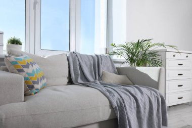 Pencerenin yanındaki çekmeceleri ve kanepesi olan rahat bir oturma odası. İç tasarım