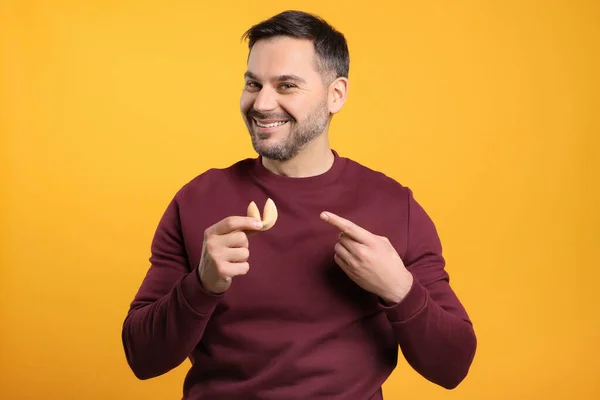 Ευτυχισμένος Άνθρωπος Κρατώντας Νόστιμο Μπισκότο Τύχης Πρόβλεψη Πορτοκαλί Φόντο — Φωτογραφία Αρχείου
