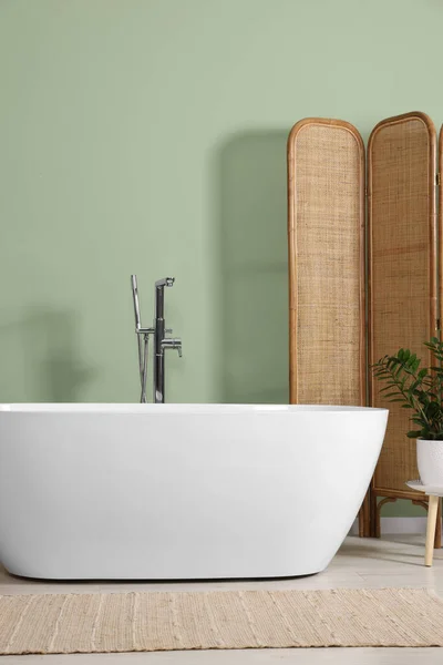现代陶瓷浴缸和美丽的植物靠近浅绿色的墙壁浴室 室内设计 — 图库照片