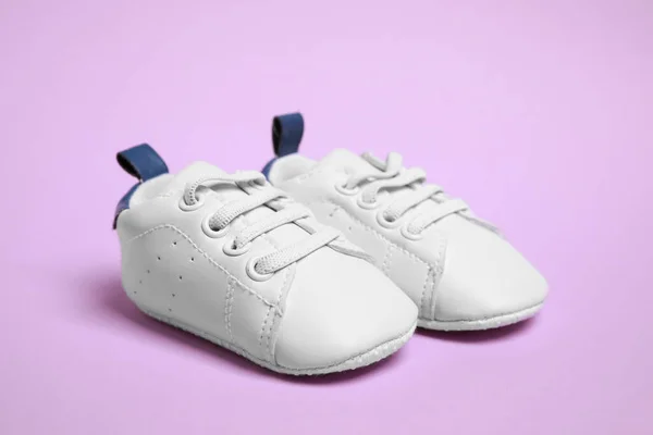 보라색 배경에 귀여운 아기용 신발들 — 스톡 사진