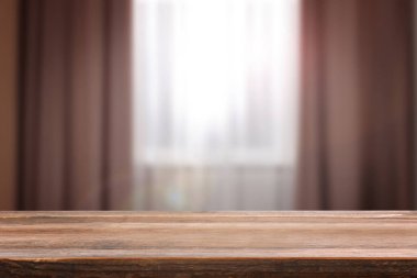 Boş ahşap masayı perdeli pencereye dayayın. Tasarım için boşluk