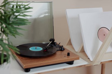 Beyaz masadaki vinil plaklı şık pikap.