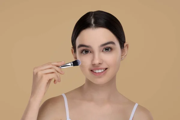 Teenage Girl Applying Foundation Face Brush Beige Background — Stock Photo, Image