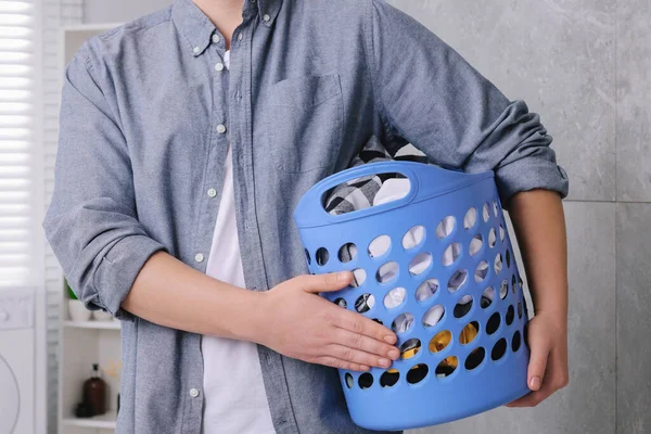 バスルームの洗濯でいっぱいのバスケットを持つ男 クローズアップ — ストック写真