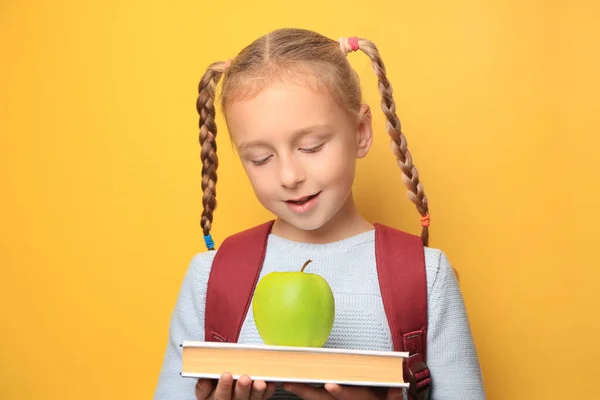 Cute Little Girl Jabłkiem Plecakiem Książki Żółtym Tle — Zdjęcie stockowe