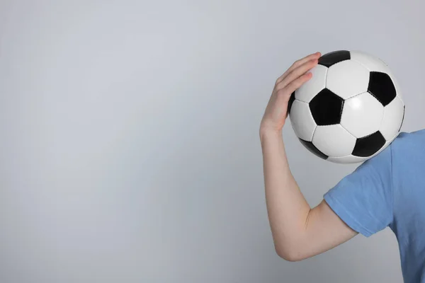 ライトグレーの背景にサッカーボールを持つ男の子 クローズアップ テキストのスペース — ストック写真