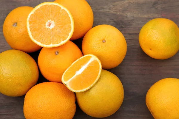 Bir Çoğu Bütün Portakalları Ahşap Masada Düz Bir Şekilde Kesiyor — Stok fotoğraf