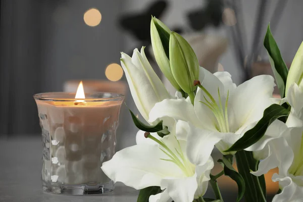 洁白的百合花和室内点燃的蜡烛 防爆效果 — 图库照片