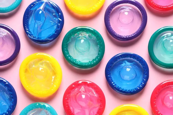 Preservativos Coloridos Sobre Fondo Rosa Planas —  Fotos de Stock