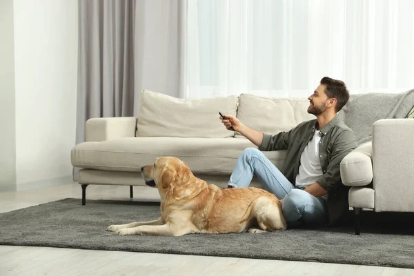 Evinde Labrador Köpeğinin Yanında Televizyonu Açan Bir Adam — Stok fotoğraf