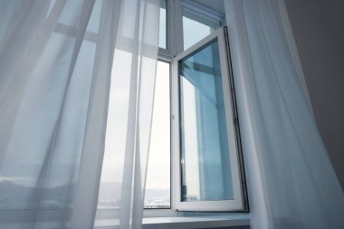 Açık pencere ve zarif beyaz perdeler. İç tasarım