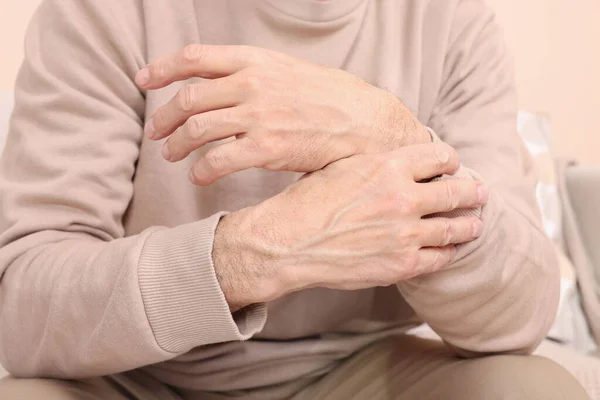 stock image Senior man suffering from pain in his wrist at home, closeup. Arthritis symptoms