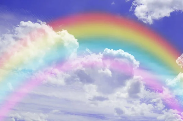 Beautiful sky with bright rainbow and fluffy clouds