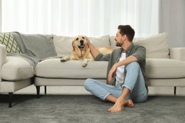 Evinde şirin Labrador köpeği olan mutlu bir adam.