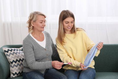 Genç bir kadın, bebeğinin bedenini hamilelik testi için annesine gösteriyor. Müstakbel toruna büyük baba tepkisi