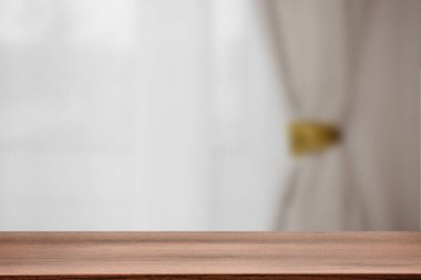 Boş ahşap masayı perdeli pencereye dayayın. Tasarım için boşluk