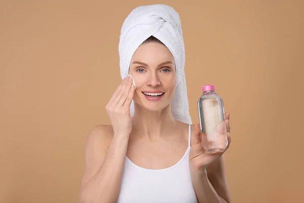Piękna Kobieta Ręczniku Frotte Usuwanie Makijażu Podkładką Bawełnianą Beżowym Tle — Zdjęcie stockowe