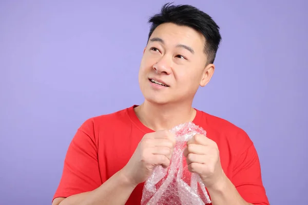 Aziatische Man Met Bubble Wrap Paarse Achtergrond — Stockfoto