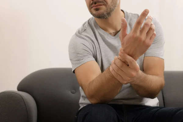 Man Met Pijn Zijn Hand Bank Binnen Close — Stockfoto