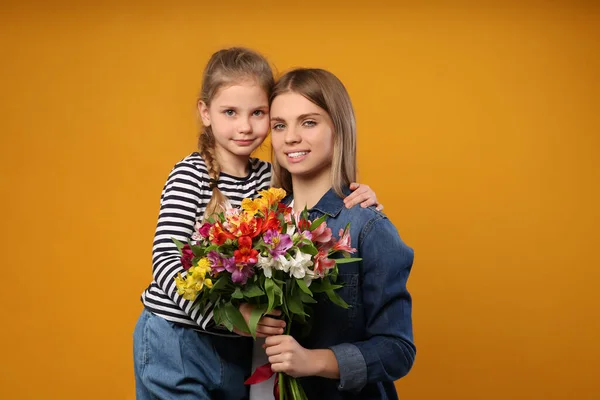 Kislány Gratulál Anyjának Narancssárga Hátterű Virágokkal Boldog Anyák Napját — Stock Fotó