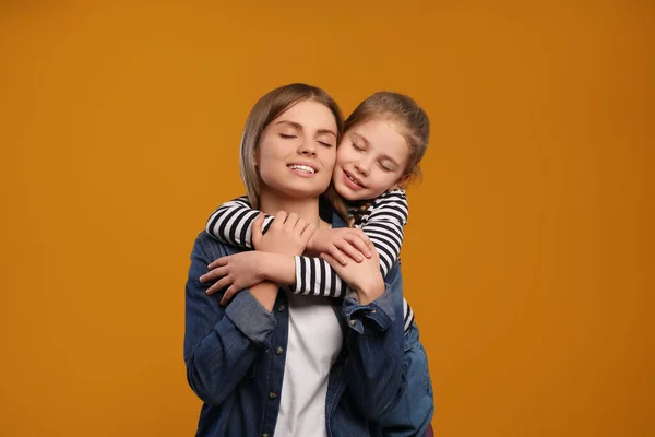 Küçük Kız Turuncu Arka Planda Annesine Sarılıyor Anneler Günün Kutlu — Stok fotoğraf