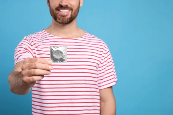 Vista Perto Homem Feliz Com Preservativo Fundo Azul Claro Espaço — Fotografia de Stock