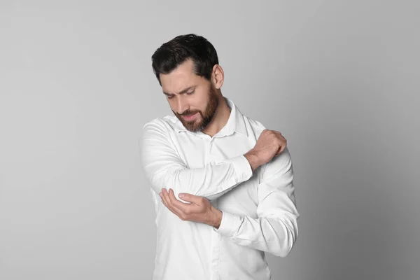 軽い背景で肘の痛みに苦しむ男 関節炎の症状 — ストック写真
