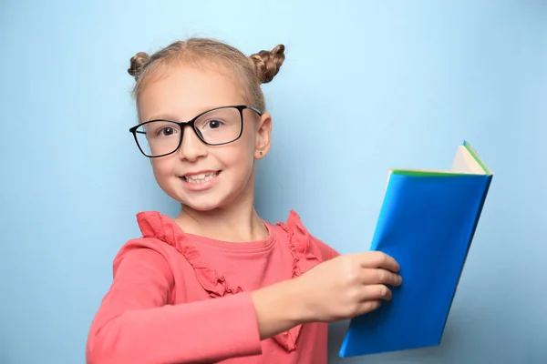 Cute Little Girl Okularach Podręcznik Jasnoniebieskim Tle — Zdjęcie stockowe