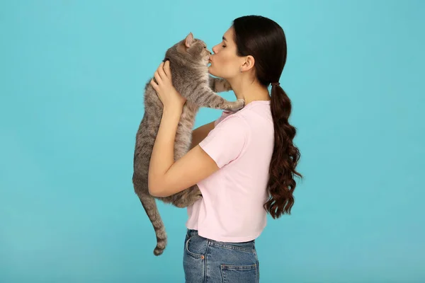 Νεαρή Γυναίκα Φιλάει Την Αξιολάτρευτη Γάτα Της Γαλάζιο Φόντο — Φωτογραφία Αρχείου