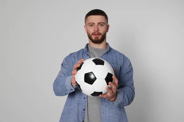 ライトグレーの背景にサッカーボールを持つアスレチック若い男 選択的フォーカス — ストック写真