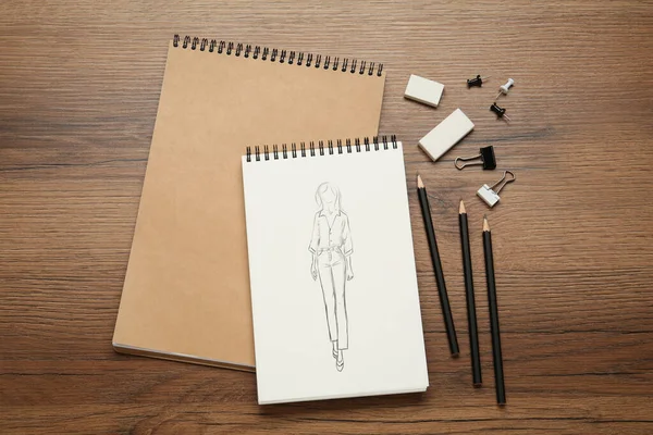 木制桌子上的衬垫上印有时尚服装的素描 时装设计师的写字台 有文具 — 图库照片