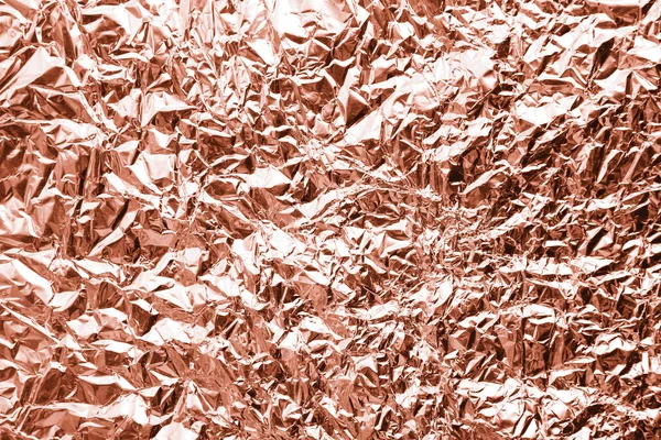 Crumpled rose gold foil as background, closeup view
