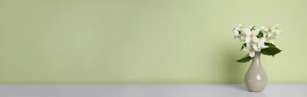 Букет Красивых Жасминовых Цветов Вазе Столе Возле Светло Зеленой Стены — стоковое фото