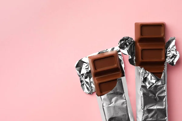 Deliciosas Barras Chocolate Envueltas Papel Aluminio Sobre Fondo Rosa Planas — Foto de Stock