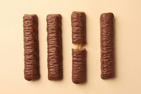 Doces Saborosas Barras Chocolate Com Caramelo Fundo Bege Flat Lay — Fotografia de Stock
