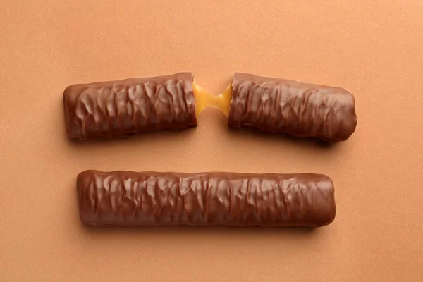 Dulces Sabrosas Barras Chocolate Con Caramelo Sobre Fondo Beige Planas —  Fotos de Stock