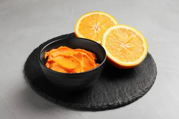 Bowl of cream painted with natural food coloring and orange on light table