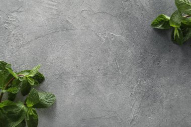 Yemek fotoğrafçılığı. Gri desenli masadaki taze aromatik nane yaprakları, metin için yeri olan düz yataklar.